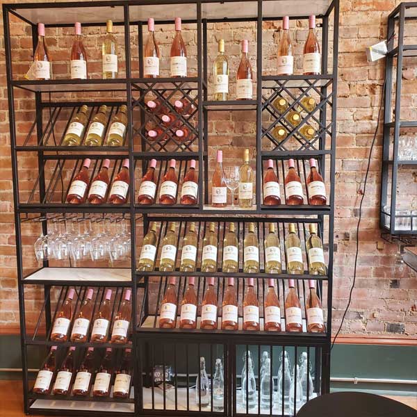 Bottles of wine on a wall rack in the Oakland Creek Vineyards tasting room